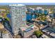 Aerial view of condo building overlooking a serene lake, cityscape, pool and tennis court at 150 E Robinson St # 3408, Orlando, FL 32801