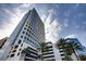 Contemporary condominium high rise featuring balconies and a parking garage set against a cloudy blue sky at 150 E Robinson St # 3408, Orlando, FL 32801