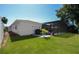 View of backyard featuring a screened-in pool, a well-maintained lawn, and a charming white house on a sunny day at 1529 Glastonberry Rd, Maitland, FL 32751
