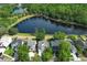 Aerial view of neighborhood homes with mature trees and a lake in the background at 1645 Boulder Creek Ct, Apopka, FL 32712