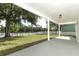 Covered patio with view of a large backyard, lake, and white picket fence at 1645 Boulder Creek Ct, Apopka, FL 32712