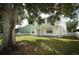 A large backyard features a covered porch and white picket fence with a view of a neighbor's house at 1645 Boulder Creek Ct, Apopka, FL 32712