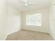 A well-lit bedroom with neutral carpet, a window, and a ceiling fan at 1645 Boulder Creek Ct, Apopka, FL 32712