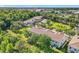 Aerial view of multi-story townhouses with lush trees, a community pool, and ample parking at 1772 Garden Sage Dr, Oviedo, FL 32765