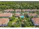 Aerial view of townhouses with community pool and playground surrounded by palm trees and manicured lawns at 1772 Garden Sage Dr, Oviedo, FL 32765