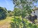 Serene backyard view showcasing a lush green lawn, mature trees, and a screened-in patio for outdoor enjoyment at 1772 Garden Sage Dr, Oviedo, FL 32765