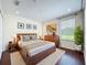 This bedroom has a wooden bed frame, recessed lights, and a large window at 1772 Garden Sage Dr, Oviedo, FL 32765