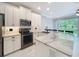 Well-lit kitchen with stainless steel appliances, white cabinets, and a breakfast bar at 1772 Garden Sage Dr, Oviedo, FL 32765