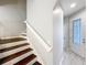 Staircase with dark wood treads and white risers leading to the upper level with glass-paneled front door view at 1772 Garden Sage Dr, Oviedo, FL 32765