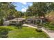 Aerial view of a well-maintained single-story home with a lush green lawn, mature trees, and a brick driveway at 2105 Fosgate Dr, Winter Park, FL 32789