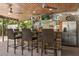 Outdoor bar area with stone accents, bar seating, refrigerator, and fun decor for a relaxed atmosphere at 2105 Fosgate Dr, Winter Park, FL 32789
