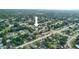 Aerial view of the neighborhood and subject home surrounded by lush foliage on a sunny day at 211 Marion Oaks Ln, Ocala, FL 34473