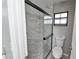 Modern bathroom with a glass-enclosed shower featuring marble-style tile and gray stone floor at 211 Marion Oaks Ln, Ocala, FL 34473