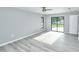 Bedroom with gray walls, gray wood flooring, a sliding door and natural light at 211 Marion Oaks Ln, Ocala, FL 34473