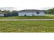 Exterior side yard of a white home, showcasing the neat lawn and a modern fence for added privacy at 211 Marion Oaks Ln, Ocala, FL 34473
