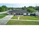 Charming single story home featuring a manicured lawn, dark roof, and a stone accent wall at 211 Marion Oaks Ln, Ocala, FL 34473
