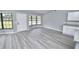 Open living room with new gray wood flooring, bay windows and a white front door at 211 Marion Oaks Ln, Ocala, FL 34473