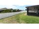 Well-maintained backyard with a white fence, lush green grass, and a screened-in patio at 212 Regency St, Davenport, FL 33896