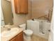 Bathroom with oak cabinets, toilet, and walk-in tub with door and hand-held showerhead at 212 Regency St, Davenport, FL 33896