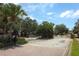 Gated community entrance featuring mature trees, a roundabout, and brick-paved streets at 212 Regency St, Davenport, FL 33896