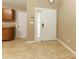 Bright entryway features neutral tile floors, leading to other rooms; adjacent to kitchen with wooden cabinets at 212 Regency St, Davenport, FL 33896