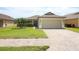 Charming home featuring a paved driveway, two-car garage, well-kept lawn, and a nicely landscaped yard at 212 Regency St, Davenport, FL 33896