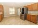 Large kitchen features stainless steel refrigerator, wood cabinets, tile floors and a window for natural light at 212 Regency St, Davenport, FL 33896