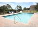 Community pool surrounded by a fence has lounge chairs where residents can relax and enjoy the outdoors at 212 Regency St, Davenport, FL 33896