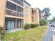 Tan condo with screened in porch and partial view of parking lot and lawn at 2131 Cascades Blvd # 306, Kissimmee, FL 34741