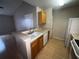 Kitchen bar opens to the living area with views of sink, cabinets, and white appliances at 2131 Cascades Blvd # 306, Kissimmee, FL 34741