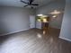 Spacious living room with vaulted ceiling, ceiling fan, wood-look floors, and kitchen view at 2131 Cascades Blvd # 306, Kissimmee, FL 34741