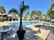 Inviting community pool area with palm trees, lounge chairs and a covered pavilion at 2131 Cascades Blvd # 306, Kissimmee, FL 34741