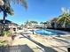 Community pool surrounded by palm trees and lounge chairs at 2131 Cascades Blvd # 306, Kissimmee, FL 34741