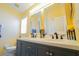 Bathroom featuring a double sink vanity with quartz countertops and decorative framed mirrors at 2709 Prestwick Ln, Kissimmee, FL 34744