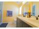 Bathroom with a double sink vanity with quartz countertops and decorative framed mirrors at 2709 Prestwick Ln, Kissimmee, FL 34744