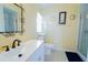 Bright bathroom featuring a quartz countertop, modern sink fixture, decorative mirror, and a glass-enclosed shower at 2709 Prestwick Ln, Kissimmee, FL 34744