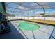 Screened-in pool with connected lounging patio and string lights at 2709 Prestwick Ln, Kissimmee, FL 34744