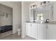 Bathroom with double vanity sinks, granite counters, and a walk-in closet at 3222 Sweet Acres Pl, St Cloud, FL 34772