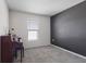 A cozy carpeted bedroom with a black accent wall and a window at 3222 Sweet Acres Pl, St Cloud, FL 34772
