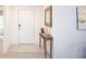 Neat entryway with a stylish console table, decorative mirror, and view to the home's interior at 3238 Viceroy Ct, Poinciana, FL 34759
