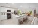 Open concept kitchen featuring white cabinets, stainless steel appliances, and a central island with seating at 3238 Viceroy Ct, Poinciana, FL 34759