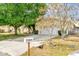 View of the house showing the driveway, partial lawn, and curb with mature trees at 329 Alegriano Ct, Kissimmee, FL 34758