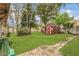 This spacious backyard features a lush lawn and a charming red shed, perfect for storage or a hobby space at 334 Terrace Dr, Oviedo, FL 32765