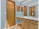 Bathroom featuring a vanity with a sink, a decorative mirror, and wood cabinets at 334 Terrace Dr, Oviedo, FL 32765