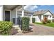 Home exterior featuring a brick driveway, neatly trimmed bushes, and a view of the front door and garage at 338 Wooded Vine Dr, Winter Springs, FL 32708