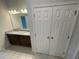 A bathroom featuring double sinks, a granite countertop, and a large mirror with vanity lighting at 3408 Curlew Ave, Leesburg, FL 34748