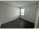This bedroom features hard wood floors, a window, and neutral walls at 3408 Curlew Ave, Leesburg, FL 34748