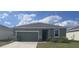 Charming single-Gathering home showcasing a well-maintained yard and a two-car garage on a sunny day at 3408 Curlew Ave, Leesburg, FL 34748