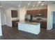 Modern kitchen features granite countertops, a central island, stainless steel appliances, and wood cabinets at 3408 Curlew Ave, Leesburg, FL 34748