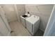 A compact laundry room with white washer and dryer units with overhead wire shelving at 3408 Curlew Ave, Leesburg, FL 34748